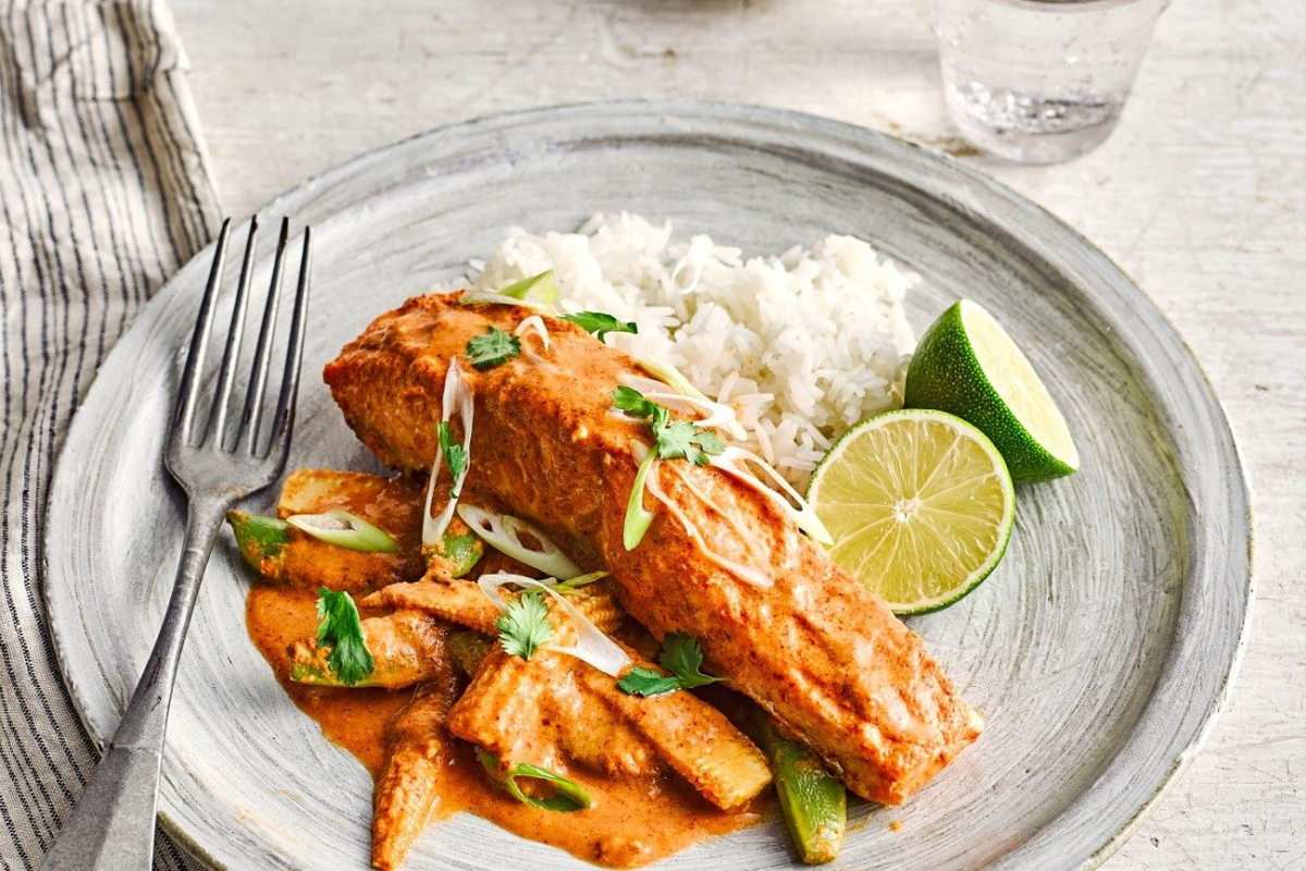 Тарелка с запечённым лососем в соусе, рисом и дольками лайма