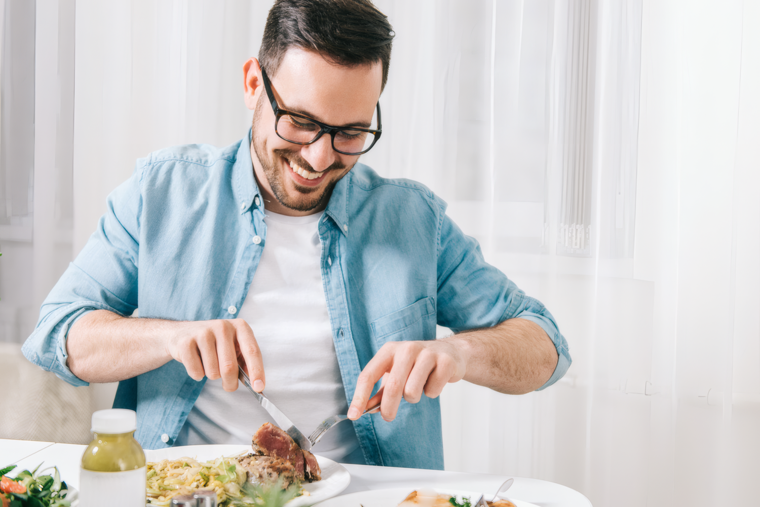 Мужчина в очках с аппетитом ест здоровую пищу дома