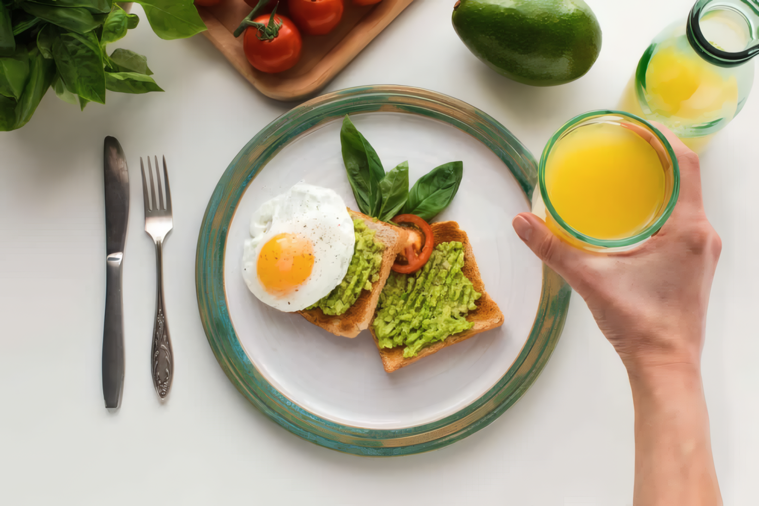 Завтрак с тостами, авокадо, яйцом и стаканом апельсинового сока на белом столе